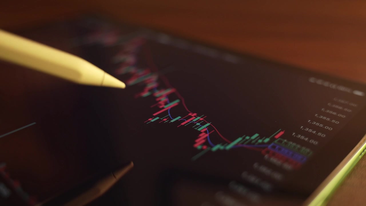 Trader che analizza i grafici del mercato azionario su un iPad tramite una piattaforma di intermediazione.