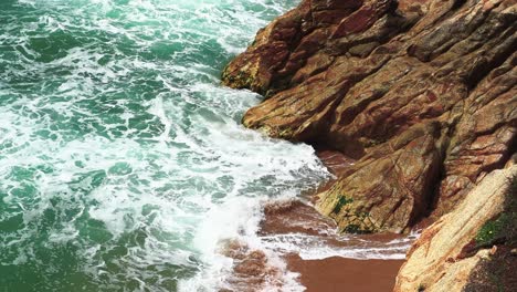 Top-view-of-waves-crashing-against-the-rocks