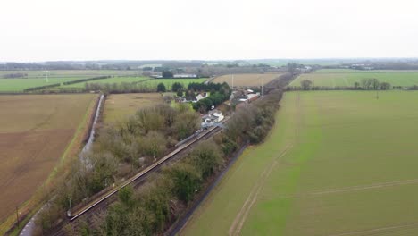 a drone reveal shot of a village train station in kent, england