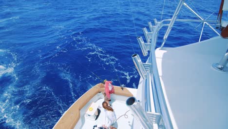 reveal pan of people on lower deck of yacht on caribbean sea, seen from above