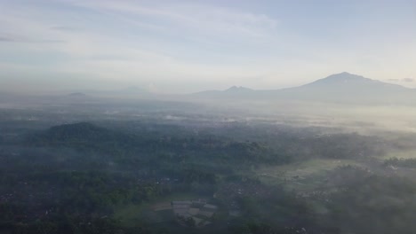 Aerial-view-showing-overcast-morning-landscape-with-mountains-in-background-in-Asia