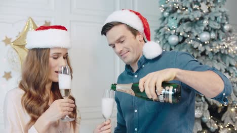 Handsome-man-pouring-champagne-on-glasses.-Pretty-woman-flirting-man