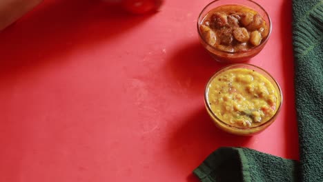rotación chole bhature o curry de garbanzos y puri frito servido en vajilla de terracota sobre fondo rojo