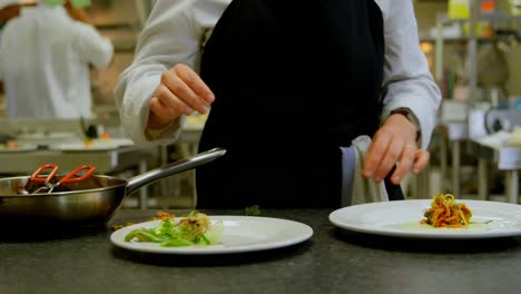 female chef arranging food on plate in kitchen 4k