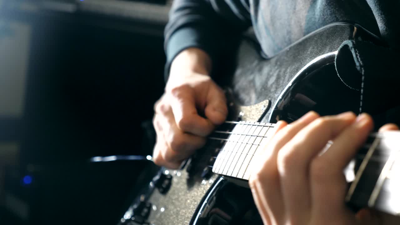 기타리스트의 손가락을 어주고, 을 고, 남자 팔은 록 음악의 솔로를 연주하고, 남자 음악가의 손은 전기 기타를 연주하며, 스튜디오에서 아름다운 검은색 배경, 느린 동작.