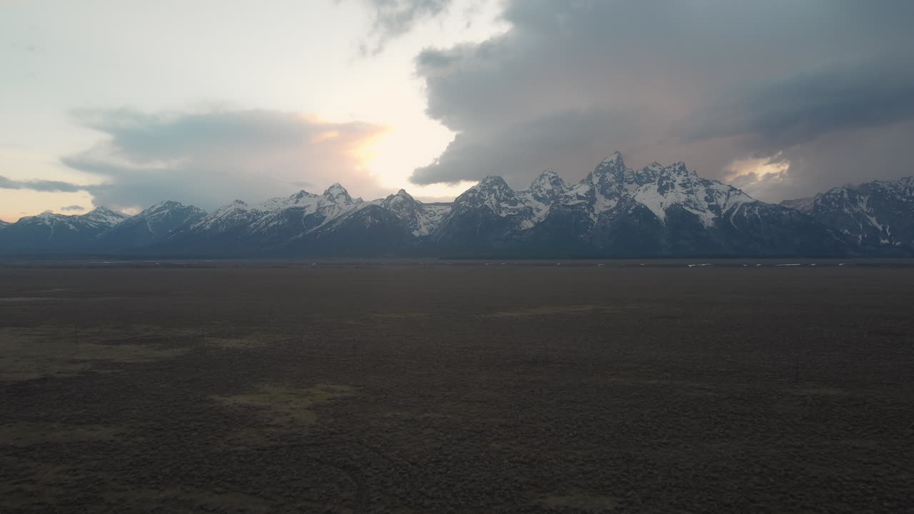 A dolly in and rising drone shot of the Grand Tetons