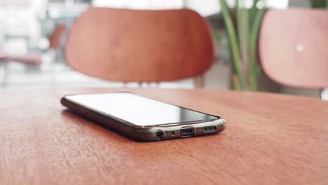 smartphone on a wooden table in a cafe