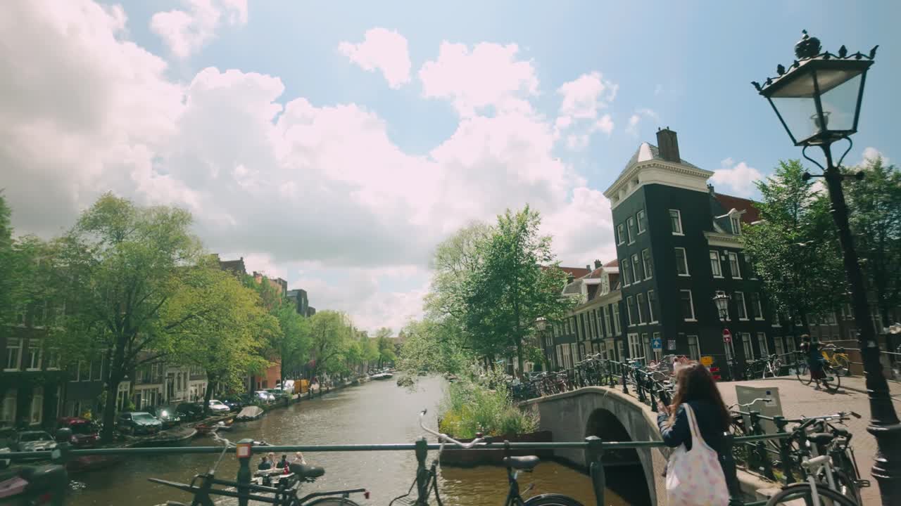 A scenic view of Amsterdam's canals and bridges on a sunny day.