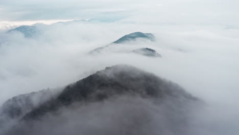 misty mountain peaks emerging from a sea of clouds, shot during early morning