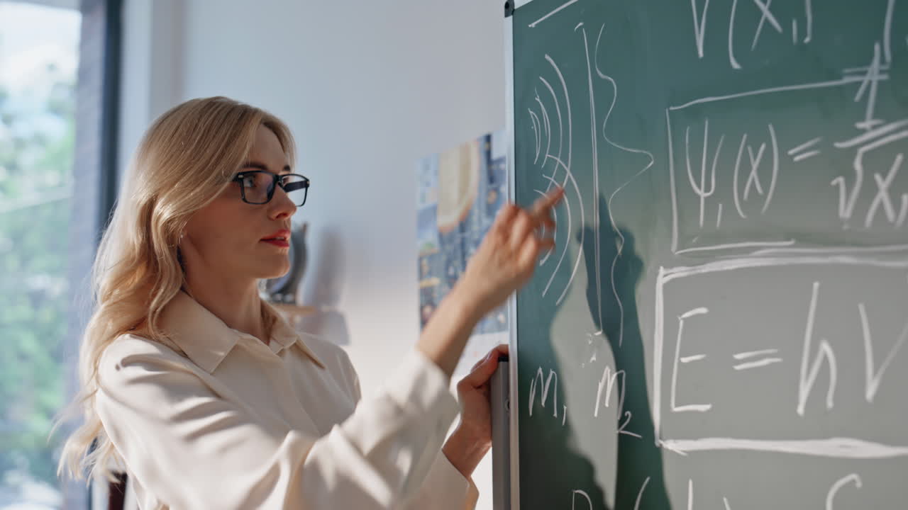 Lady explaining algebra theory writing on blackboard closeup. Woman teacher