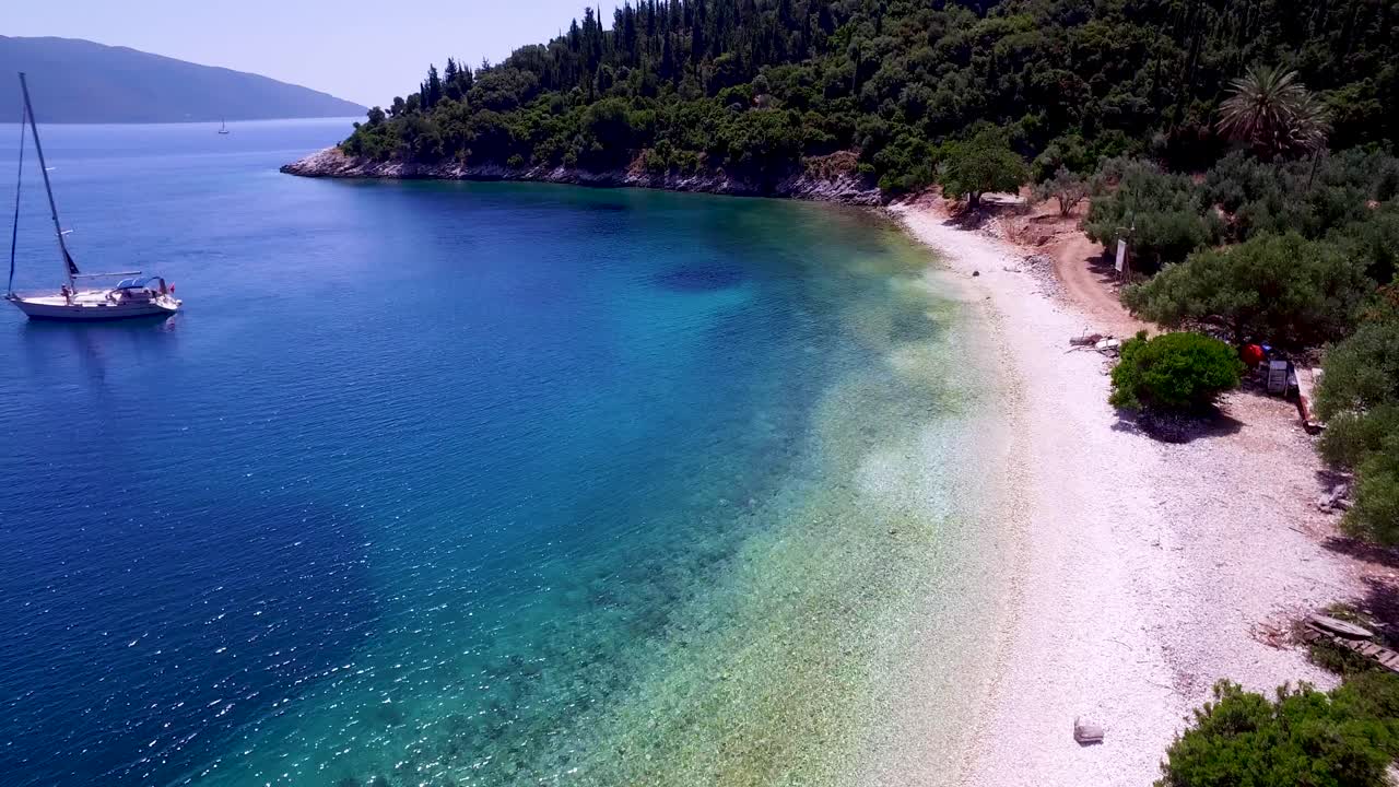 Aerial shot of Foki Beach in Kefalonia, Greece with clear turquoise waters and lush greenery
