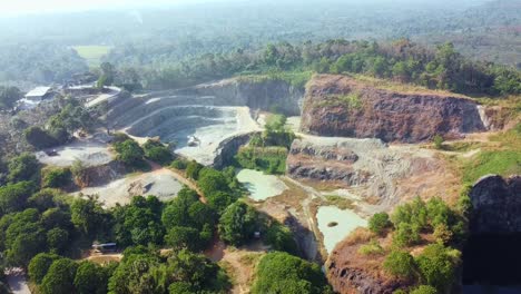 aerial view of a serene rock quarry transformed into a lush, water-filled landscape. surrounded by greenery, the deep blue water contrasts with rugged cliffs. ideal for nature, adventure,