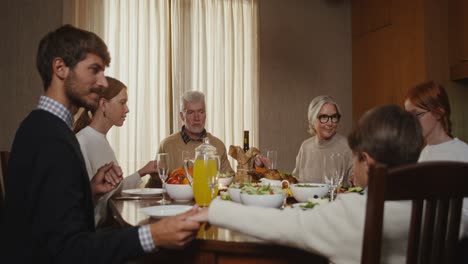 family praying together during thanksgiving dinner