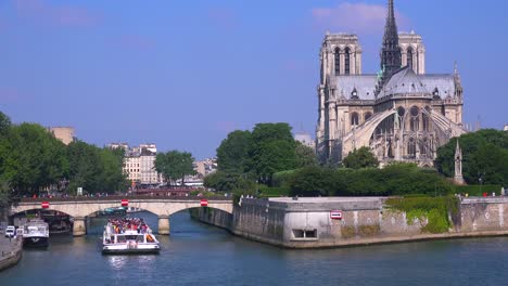 a riverboat travels under bridges near the notre dame cathedral in paris 4