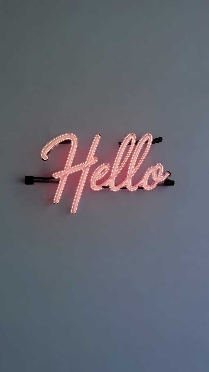 A minimalist video concept featuring a neon 'Hello' sign on a plain wall