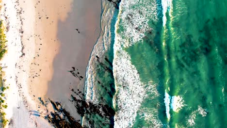 Aerial-view-from-a-drone-capturing-the-stunning-coastal-meeting-point-of-land-and-sea