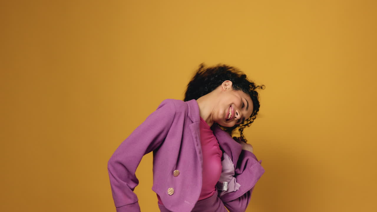 Woman with curly hair posing in studio