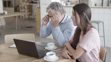 successful businesspeople sitting at table, using laptop