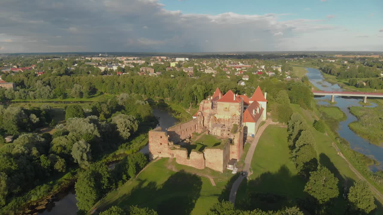 antena panorámica del castillo y la ciudad de bauska en letonia a la hora dorada