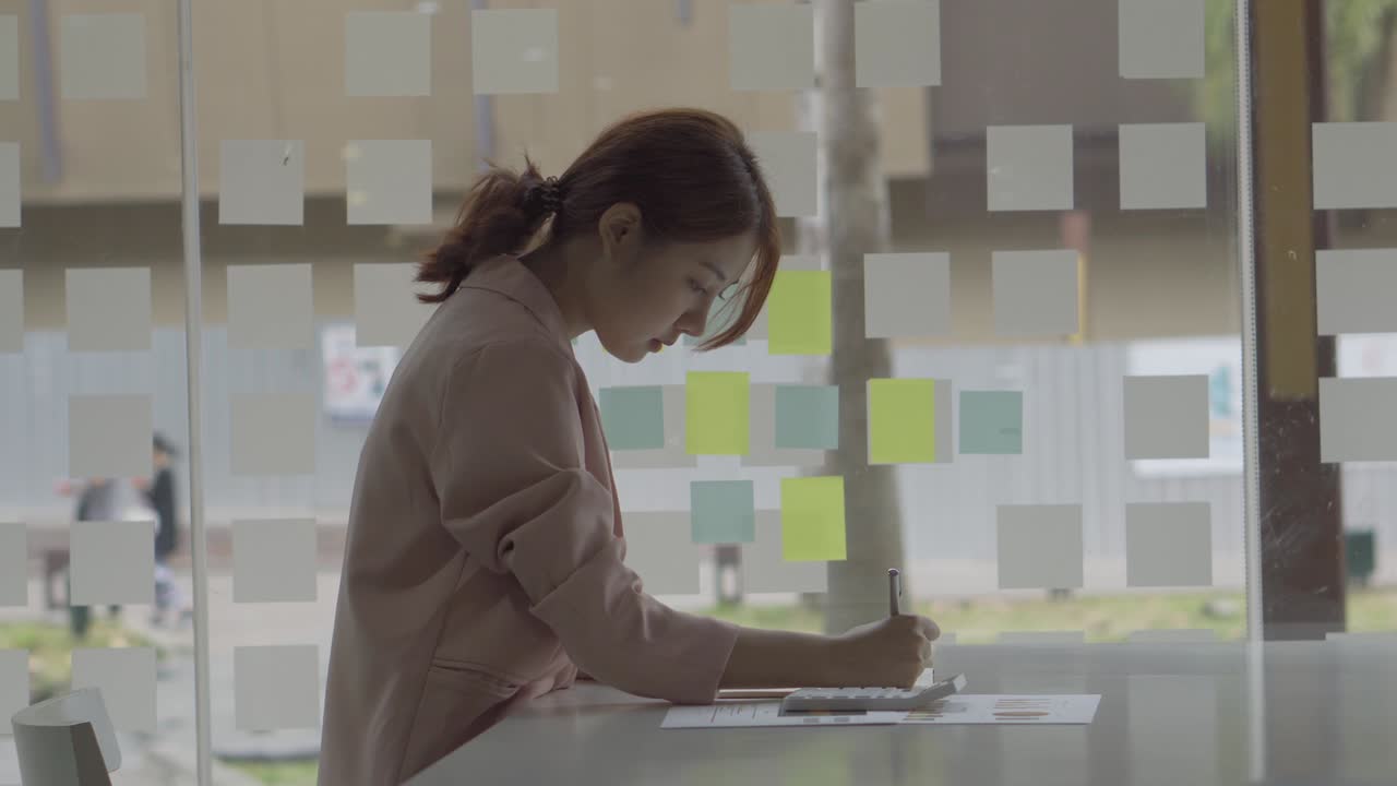 Young accountant analyzing calculating financial accounts with graphs with calculator