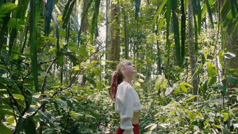 mujer feliz en el bosque mirando la exuberante selva tropical disfrutando de la belleza de la naturaleza