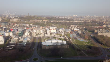 Vista-Aérea-Con-Una-Panorámica-De-Derecha-A-Izquierda-Desde-Holyrood-A-Través-De-La-Ciudad-De-Edimburgo-Hasta-El-Castillo-De-Edimburgo-En-Un-Día-Soleado,-Escocia