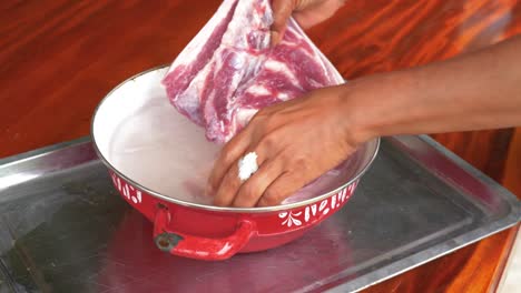 Washing-raw-pork-belly-meat-lump-in-cold-water-before-cooking