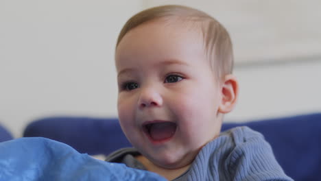 Baby-smiling-and-laughing-playing-with-a-blue-silk-with-yellow-stars-in-slow-motion