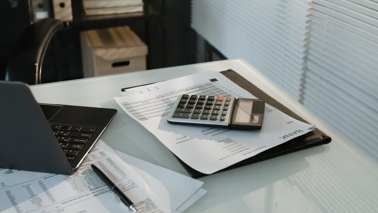 Office Desk with Laptop, Calculator, and Financial Documents