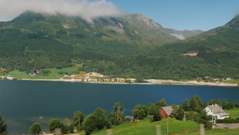 the shore of the fjord the top of the mountains are drowning in the clouds view from the window of t