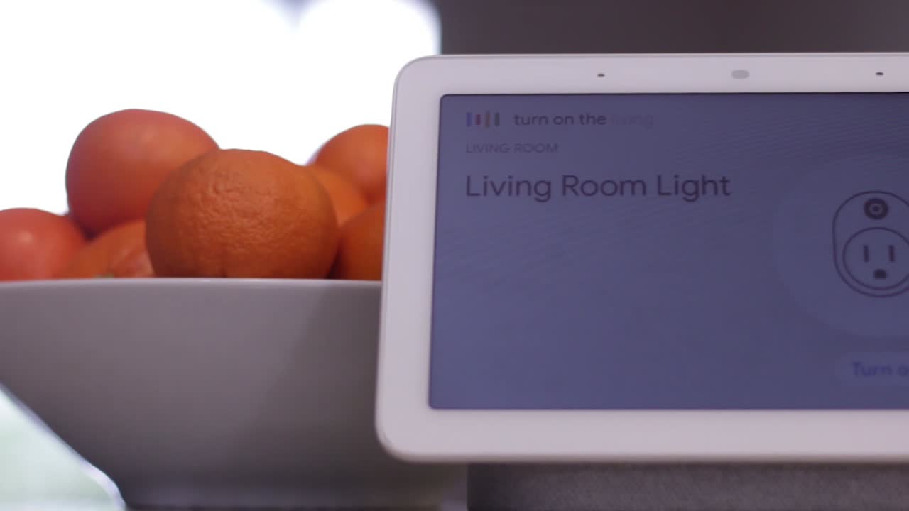 Close up of a smart home hub device turning on a light in response to a voice command