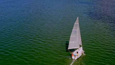 overhead view of sailboat cruising on green waters