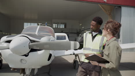 technician and inspector discussing aircraft propeller outside hangar