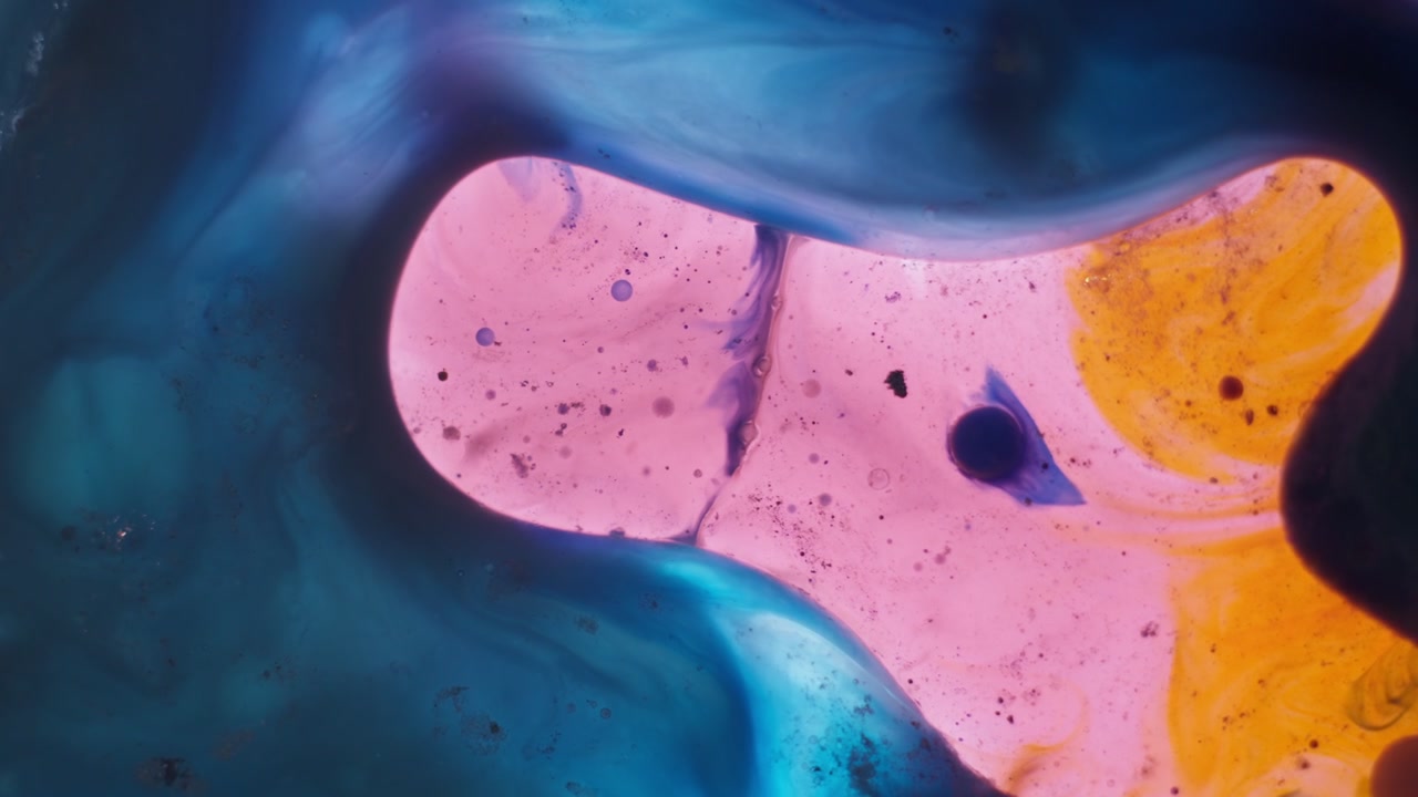 Formas orgânicas coloridas emergem dentro de redemoinhos artísticos de tinta fluida. Este experimento visual sereno e relaxante transmite uma atmosfera de ciência e laboratório, mostrando a evolução fluida em um close-up macro.