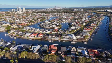 drone footage captures luxurious homes and winding waterways under bright daylight in gold coast, australia, showcasing urban and natural beauty