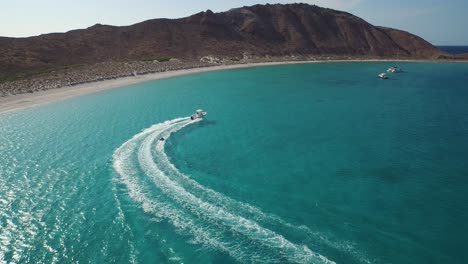 Toma-Aérea-De-Un-Tirón-Inflable-Remolcable-Por-Un-Pequeño-Bote-En-El-Mar-De-Cortez