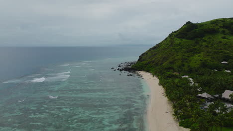 sunny tropical beach with green forest and turquoise water along island edge