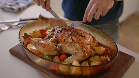 a man is cutting up a cooked chicken