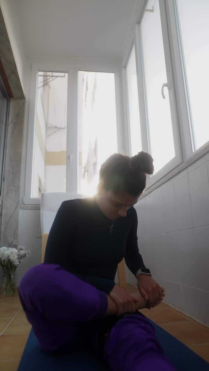 Donna che pratica yoga su un balcone