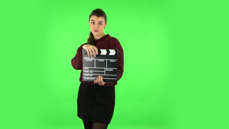 mujer con clapperboard en la pantalla verde