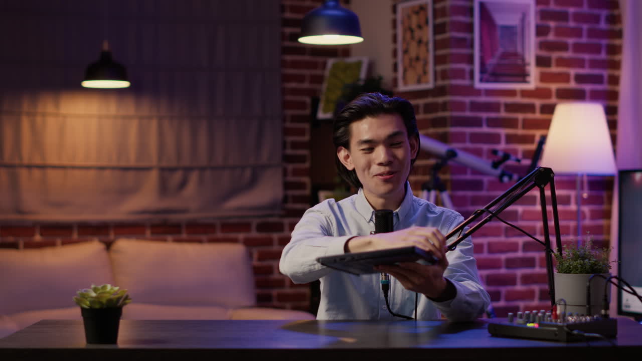 Asian man presenting laptop during podcast