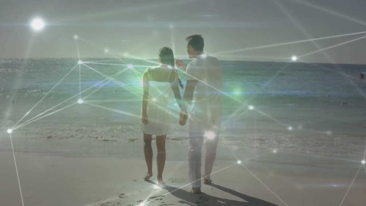 Couple holding hands on beach woman pointing initiating walking leaving steps tech overlay shifting