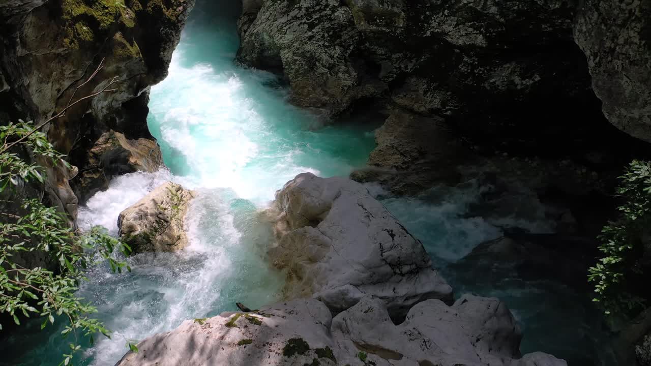 Slowly flying over a river with rapid running water. Water flows around the rock through the valley. Boka waterfall, Slovenia