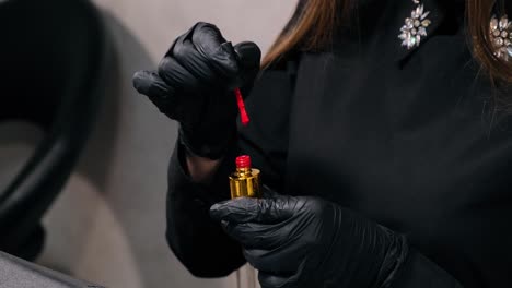 niña sosteniendo un esmalte de uñas rojo