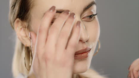 beauty model touching face skin in slow motion. close up of young woman face