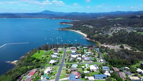 drone aerial landscape headland coastline bay with yachts boats housing streets roads cocora beach eden sapphire coast australia 4k