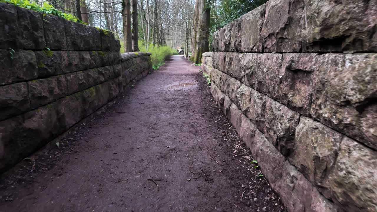 A pathway to serenity and escape a stone wall lined path through a forest