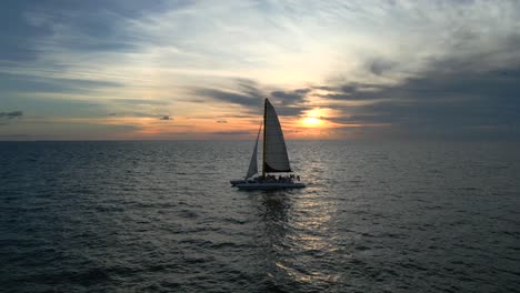 approaching a sailboat off the shore of clearwater beach at sunset