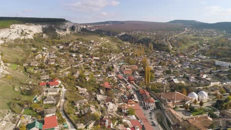 aerial view of a picturesque valley town with old buildings and surrounding nature.