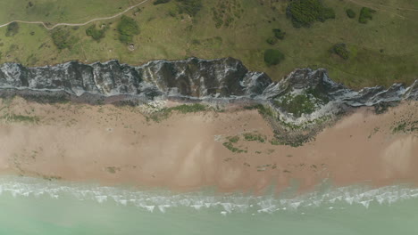 Cliff-with-Rural-Nature,-turquoise-Ocean-and-green-Meadow,-Slow-Aerial-Overhead-Top-Down-Birds-View